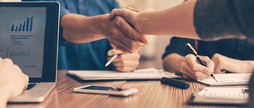 Close up of young people greeting each other at the work table.