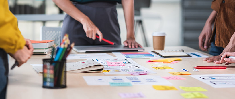 Team brainstorming on table with customer brief and color code at modern office.