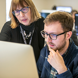 Two instructors collaborating at a computer 