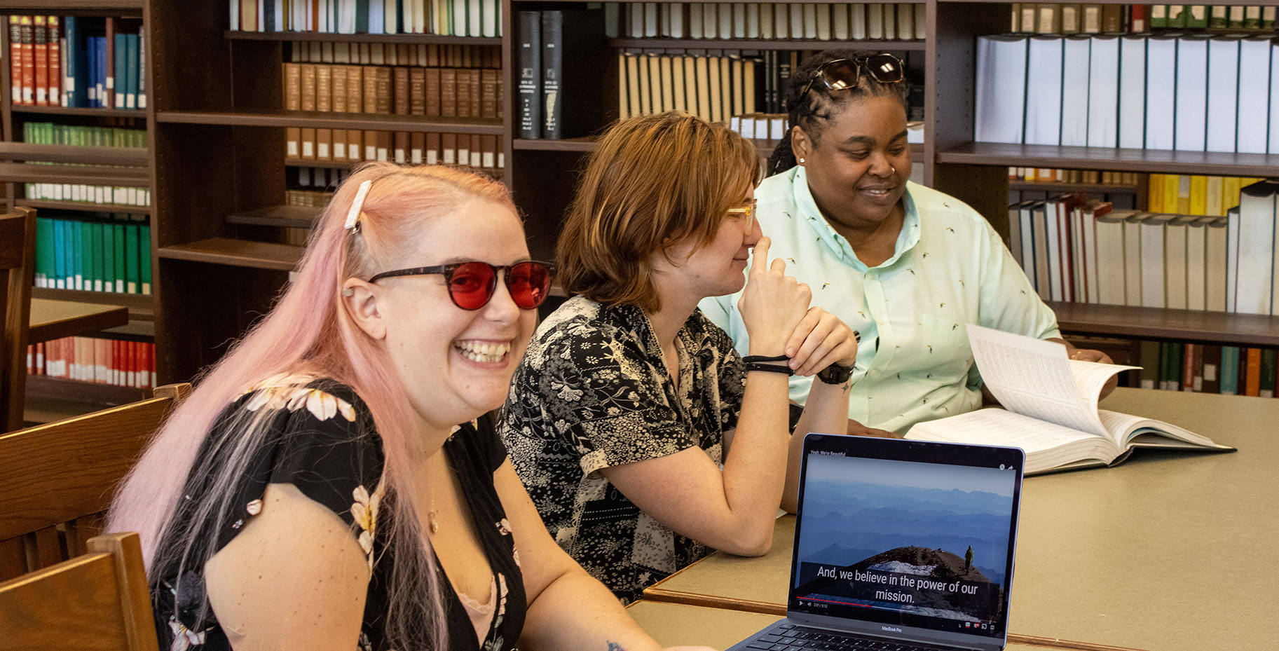 A female student has her laptop displaying a video with captioning in Thomas Cooper Library.