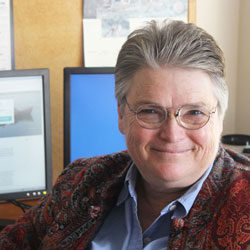 Jennifer Pournelle seated in her office in front of computer screens