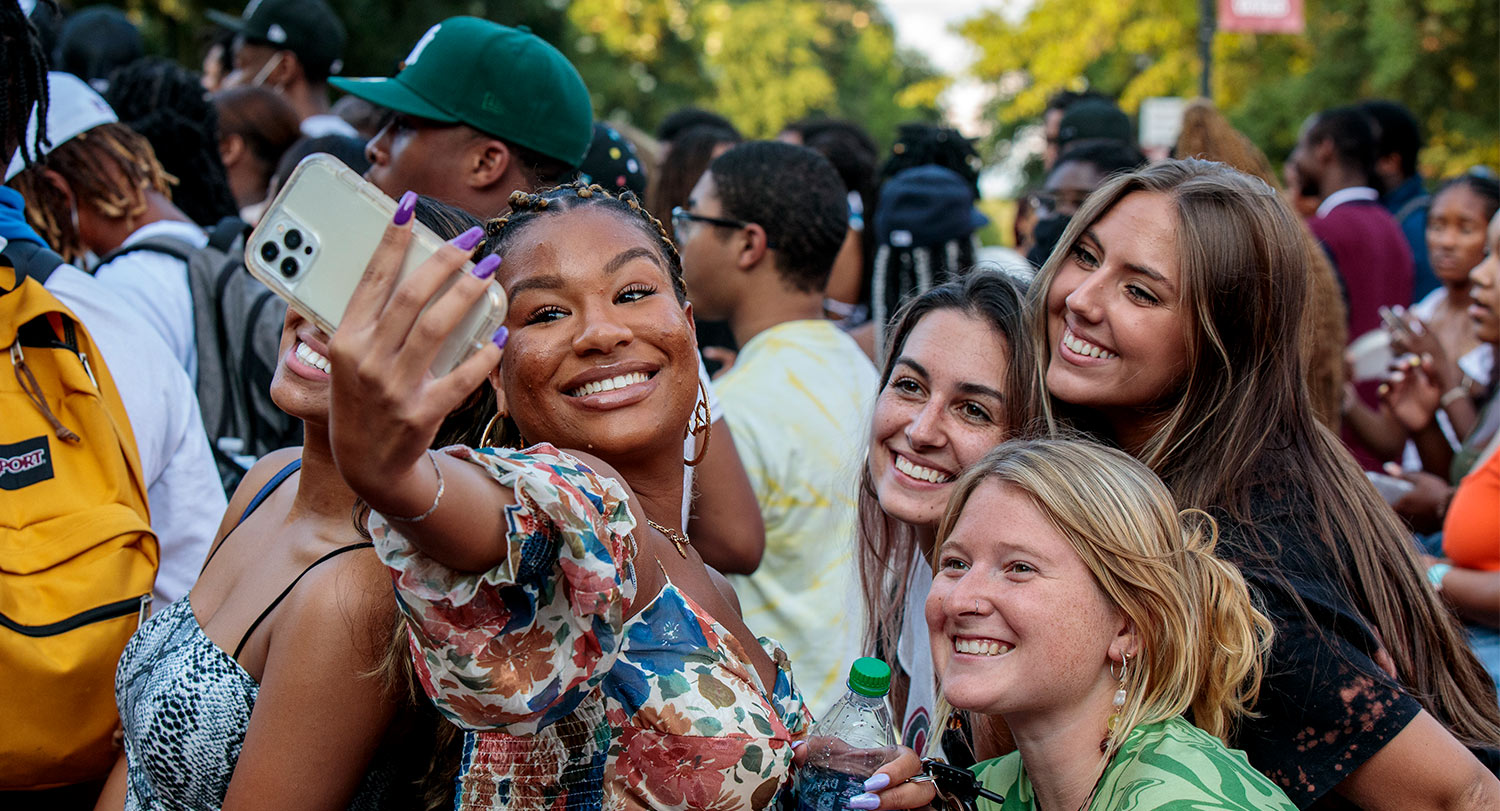 Group of students gathered together posing for a selfie. 