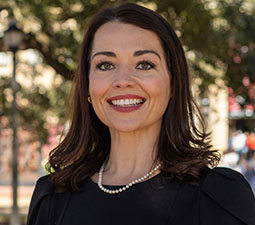 a photo of a woman in a black shirt smiling outside 