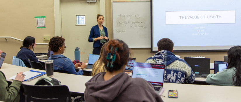 Female professor teaching in auditorium classroom.