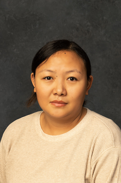 woman smiling outside with plaid jacket on
