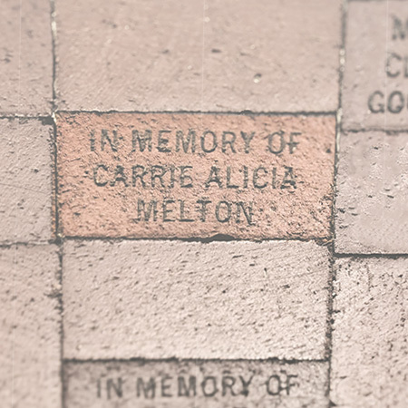 Bricks on the Horseshoe. One is engraved "In Memory of Carrie Alicia Melton."
