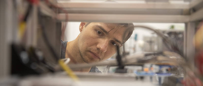 male student looks through equipment