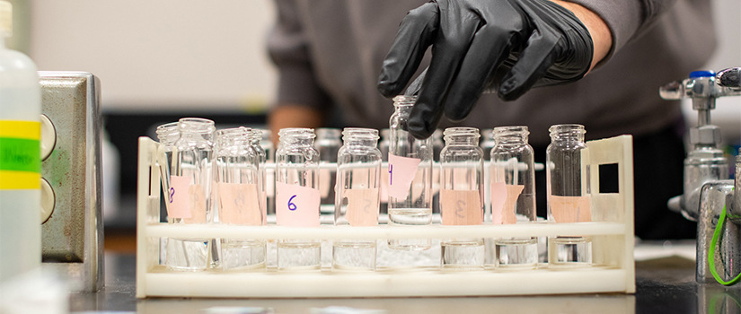 closeup of test tubes and gloved hand