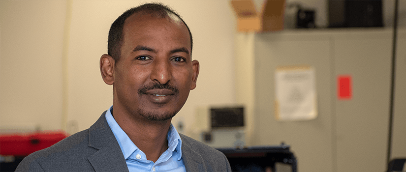 Addis Kidane stands in his lab.