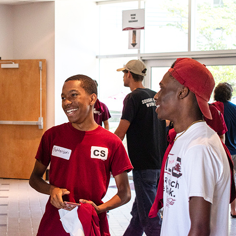 two students talk in the hallway of Swearinegn