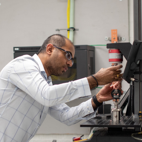 Professor sockalinham uses a machine in his lab