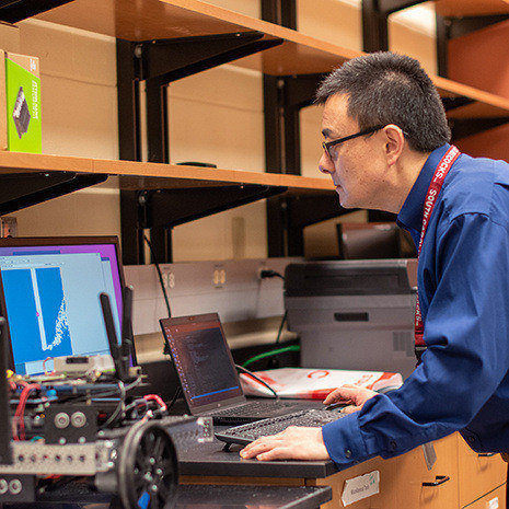 Dr. Wang works on a laptop