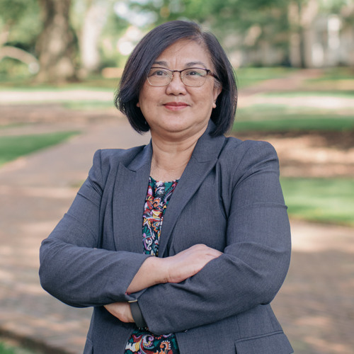 Woman with short dark hair, wearing glasses and a gray blazer