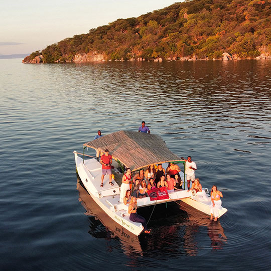 students holding up a usc flag on a boat