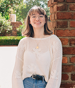 Hannah Keen leaning against a brick wall on USC's historic horseshoe.