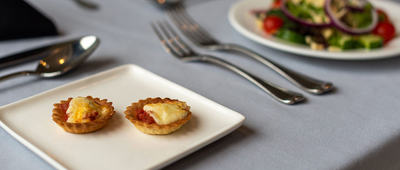 A table setting with two tomato pies and a salad.