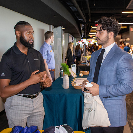 A recruiter speaks with an HRSM student at the Experience Expo.