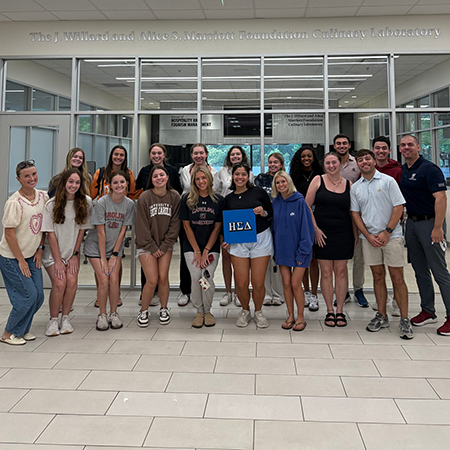 Members of Eta Sigma Delta pose for a photo in the HRSM Welcome Center