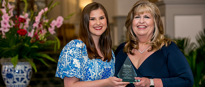 Student and faculty member holding award