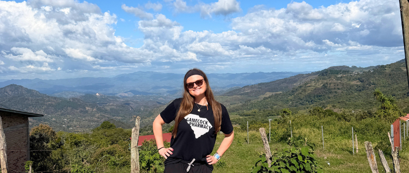 Student standing in front of mountain landscape