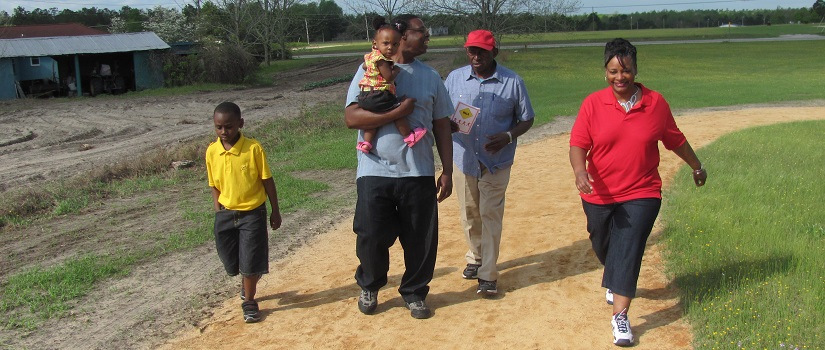 Family walking outside on a dirt path