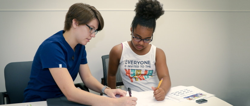 Speech and hearing specialist helping a child at a table