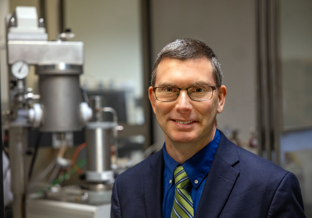 man stands in front of lab equipment