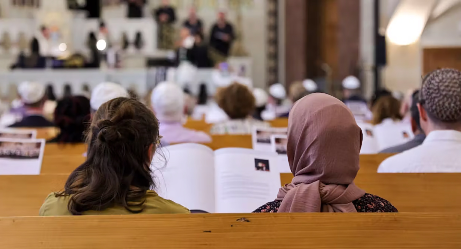 Various worshippers sit in pews in a German Church