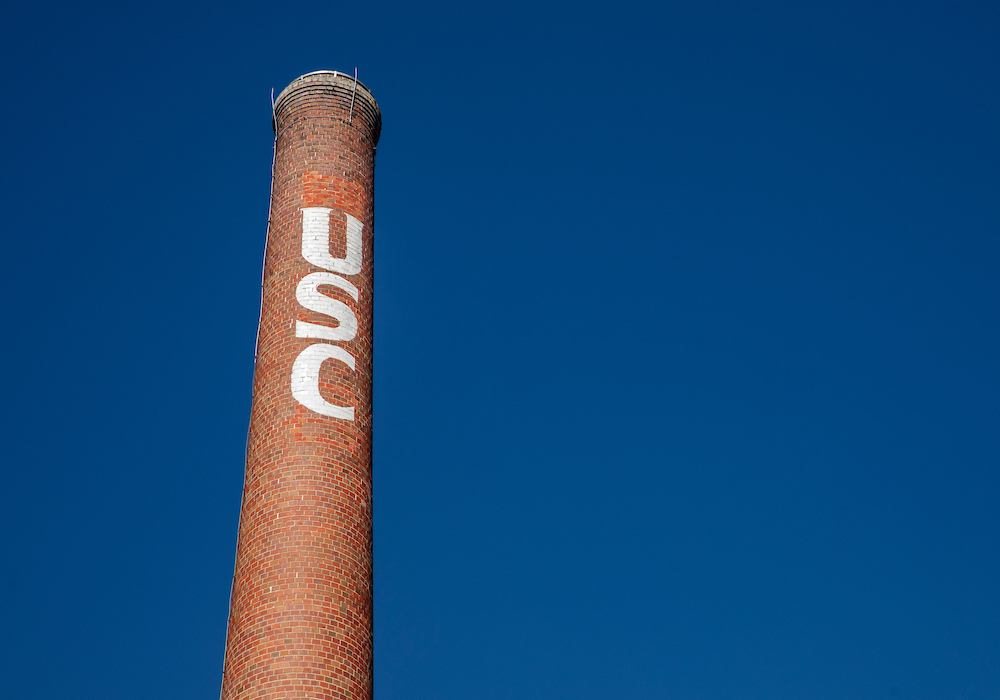 smokestack with white usc painted on it behind a blue sky
