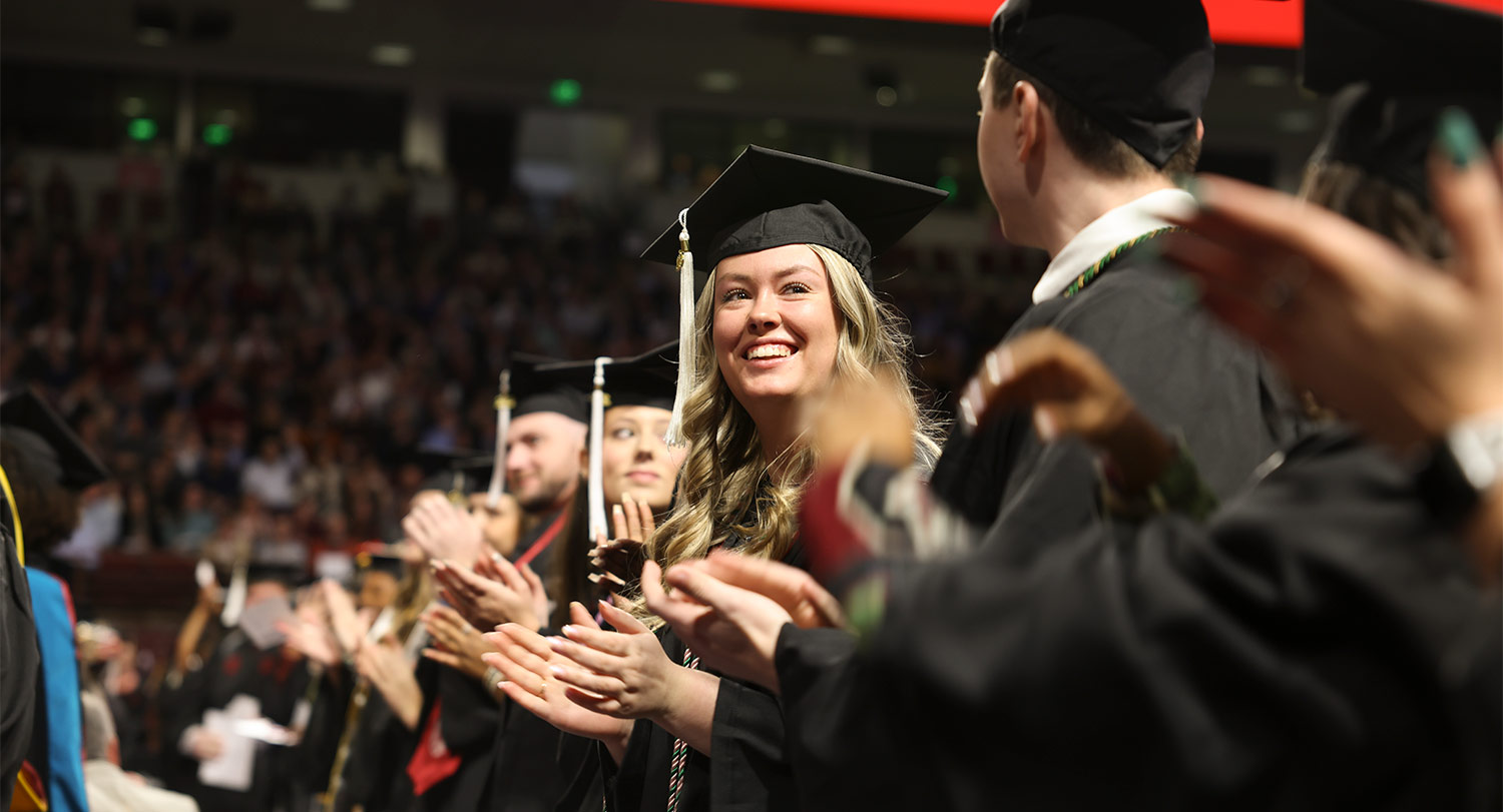 Student in cap and gown at a commencement ceremony.