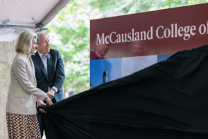 two people unveil a sign