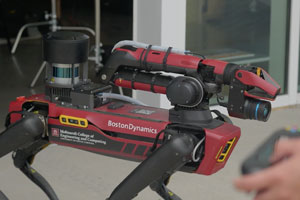 robot "dog" with hands operating a remote in the foreground