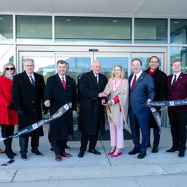 University and South Carolina leadership cut a “USC Brain Health” ribbon outside the Brain Health Center, flanked by garnet, black and white balloons.