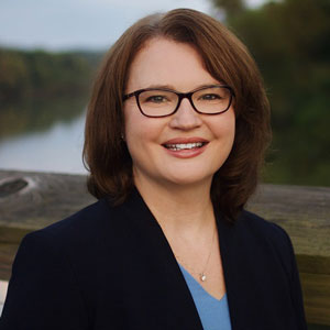 Teacher of the Year Amy Carter, brown hair, glasses, black jacket, blue top