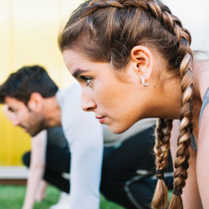 A photo of a female athlete with a male athlete in the background.