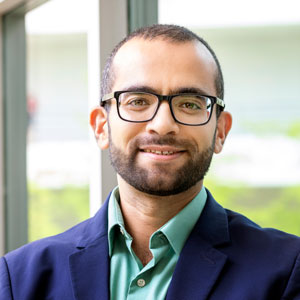 man stands in front of a wall of windows