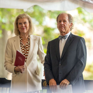 man and woman stand in front of chairs
