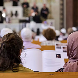 Various worshippers sit in pews in a German Church