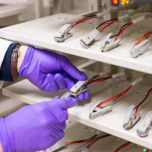 Gloved hands working with batteries and wires