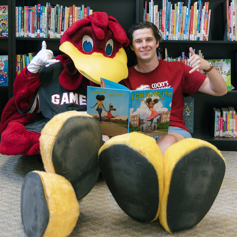 Walker Weaver and Cocky pose with a children's book.