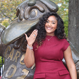 Meagan Hodges next to the Cocky statue, showing off her Carolina ring