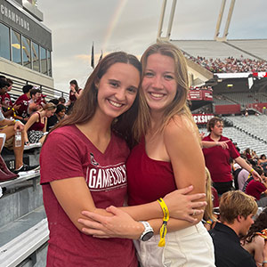 Olivia Hoyhtya and a friend pose in the stadium during a football game.