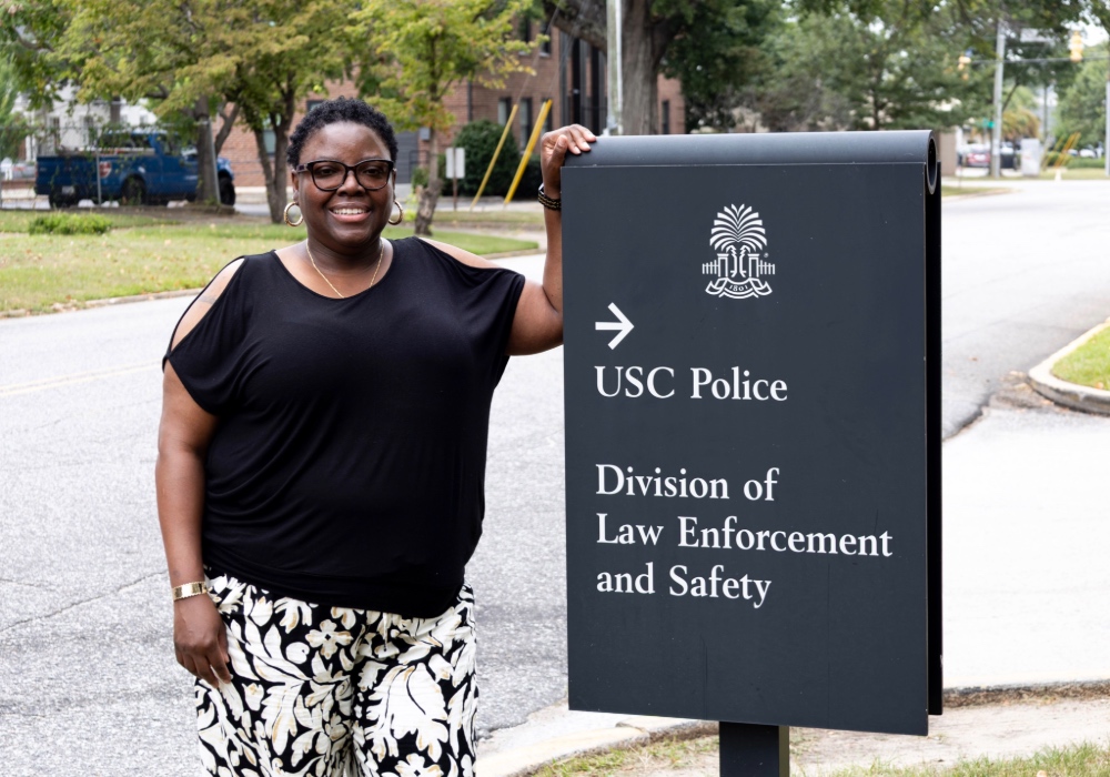Tamika Miller stands in front of the USC Police sign, a building she oversees as a custodian supervisor.